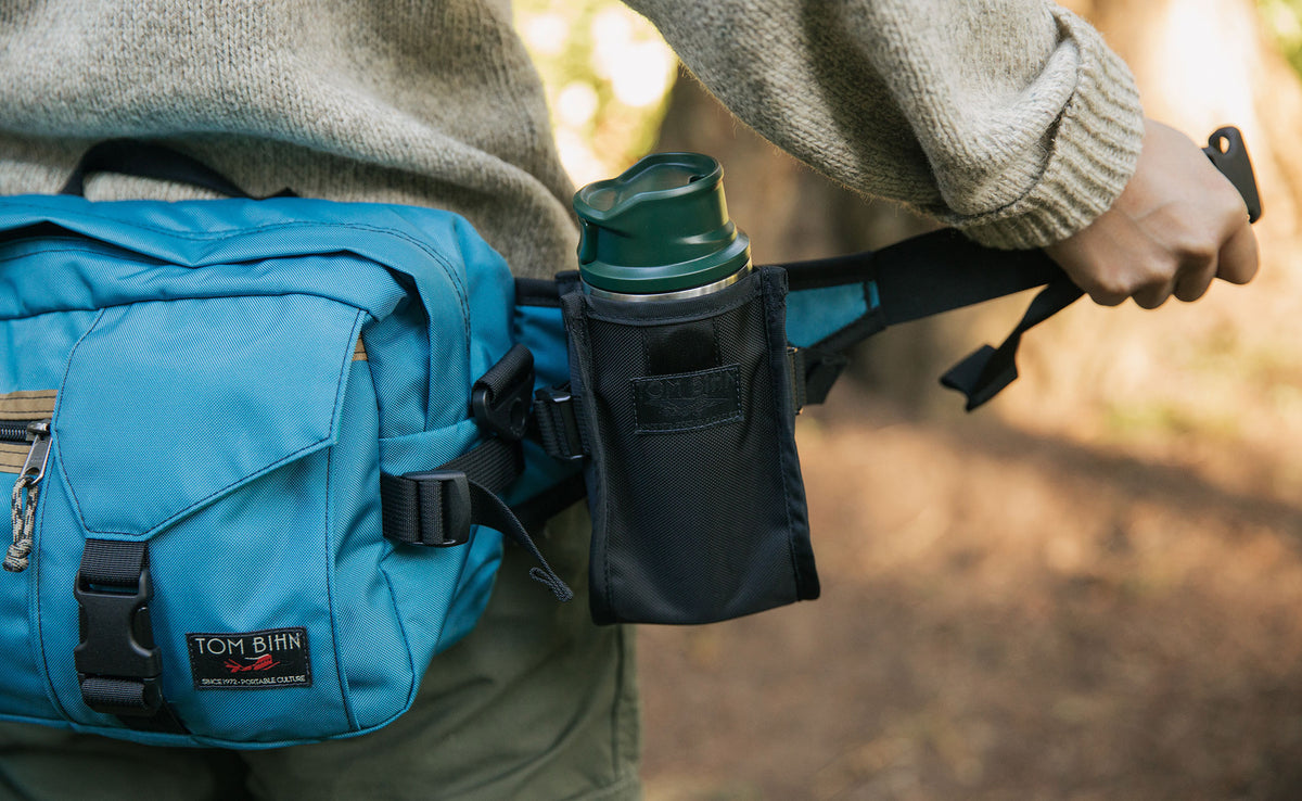 lifestyle visible^^Person holding one end of the unbuckled LGD waist strap to show how the Padded Hip Belt Pocket fits on the strap.