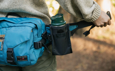 lifestyle visible^^Person holding one end of the unbuckled LGD waist strap to show how the Padded Hip Belt Pocket fits on the strap.