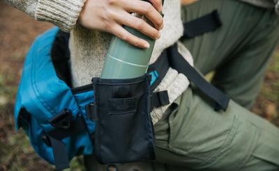 lifestyle visible^^Person pulling their water bottle out of the Padded Hip Belt Pocket.