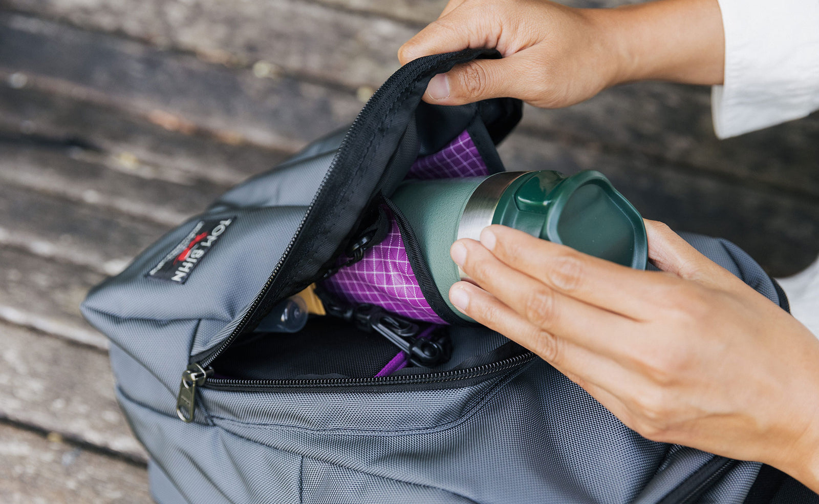 visible lifestyle^^A person removing a water bottle from the water bottle pocket in the front pocket of the Paradigm.