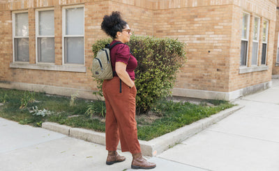 visible lifestyle^^Person carrying the Paradigm backpack in Taiga 400d Halcyon. They're standing outdoors in front of a brick building.