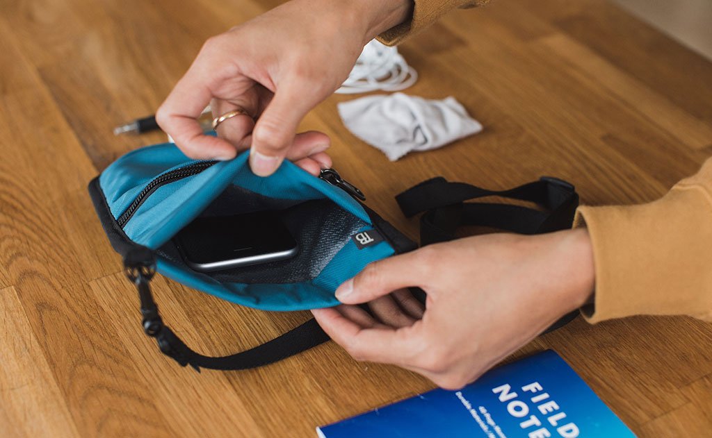 detail visible^^A phone resting in the main pocket of the P.I.K.A. Pouch.