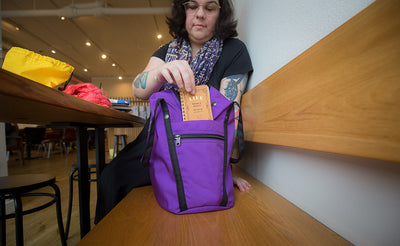 A person a notepad in the side open pocket of the Pop Tote.