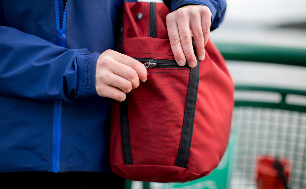 lifestyle visible^^A person accessing the side zippered pocket of the Pop Tote.