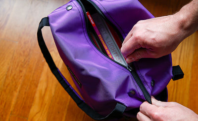 lifestyle visible^^A person zipping up a  Pop Tote filled with books.