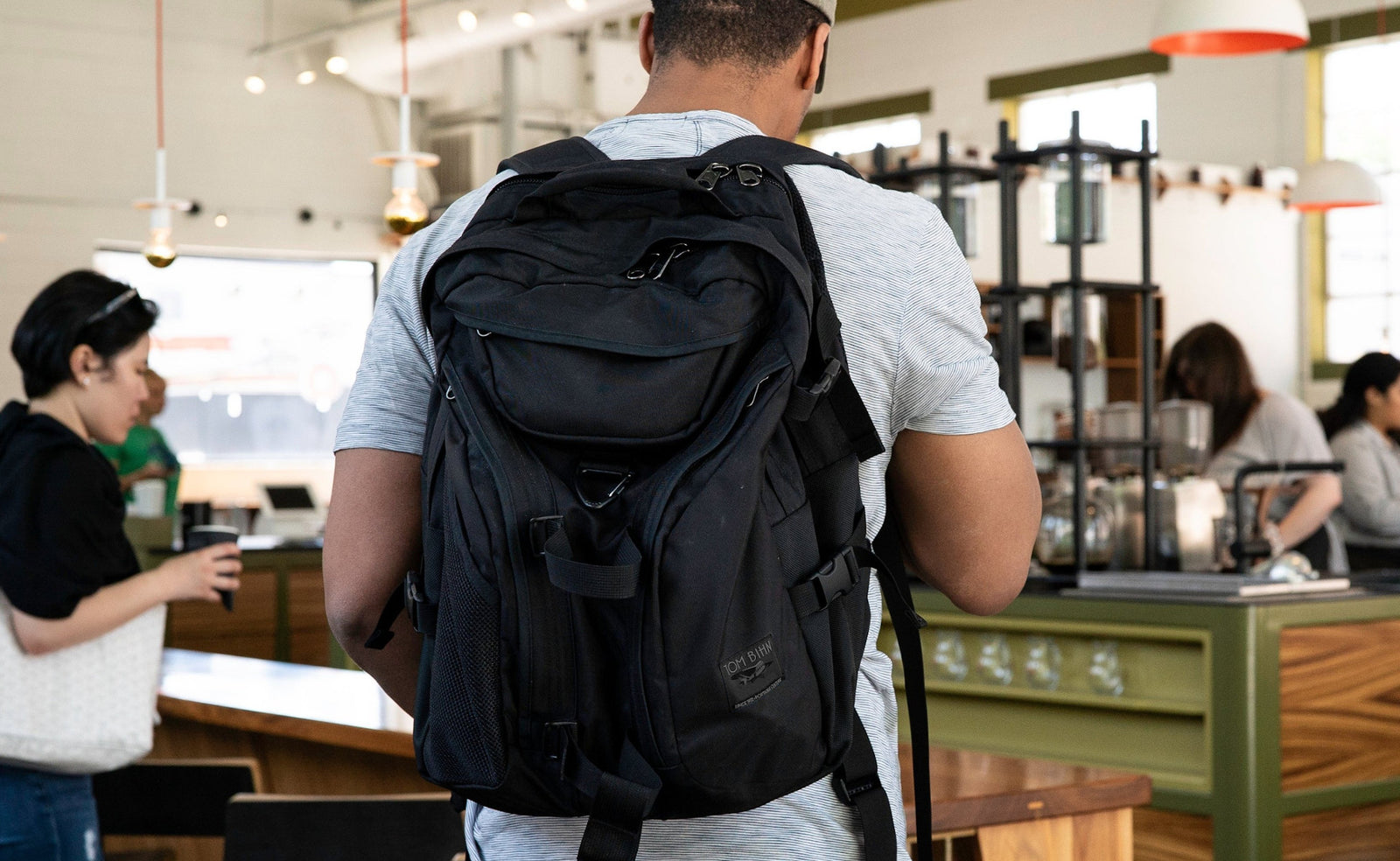 lifestyle visible^^Person wearing a Brain Bag and ordering coffee.
