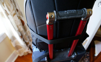 visible detail ^^ A backside shot of the Simple Rolling luggage Strap holding a bag on rolling luggage.