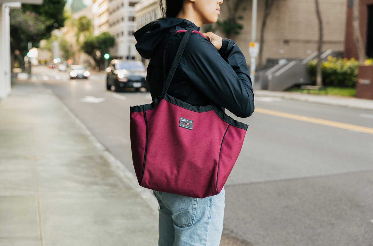 lifestyle visible^^Person carrying the Small Original Shop Bag in Red Blend.