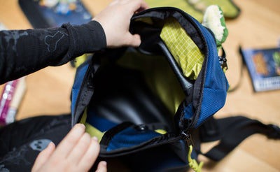 detail visible^^A child holding the the main pocket of The Sprout wide open.