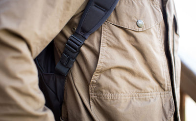 lifestyle visible^^A Black Strap Keeper holding a shoulder strap's rolled excess length out in place.