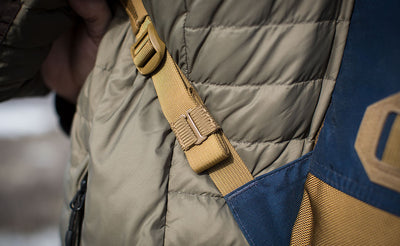 lifestyle visible^^A Coyote (brown) Strap Keeper holding a shoulder strap's rolled excess length out in place.