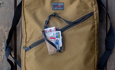 A Super Mini Ghost Whale Pouch full of Band Aids, attached to a Key Strap in a Daylight Backpack.