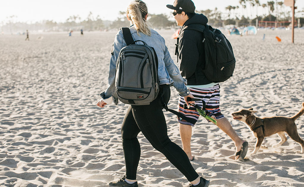 visible lifestyle^^Two people walking a dog at the beach wearing Synik 22s