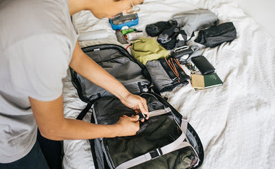 ^^A person tightening down the lash straps on some clothing in the Synik 30.
