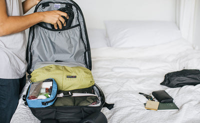 ^^A person placing a satchel into the interior elasticized pocket in the main pocket of the Synik 30.