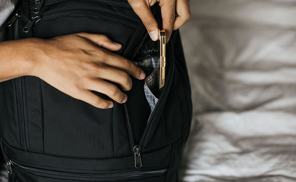 ^^A person placing a tin into the large internal pocket inside the right pocket of the Synik 30.