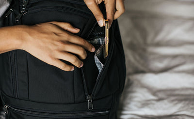 ^^A person placing a tin into the large internal pocket inside the right pocket of the Synik 30.