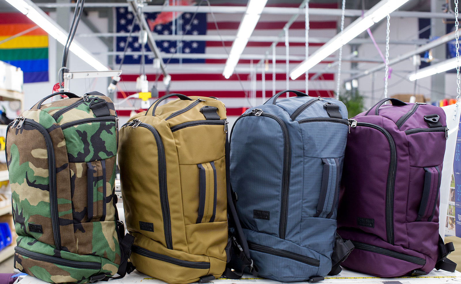 visible lifestyle^^ Four Techonaut 30s side by side, from left to right, Beaver Camo (Camouflage), Coyote (tan), Night Walk (grey blue), and Aubergine (red-ish purple).