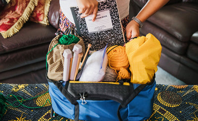 lifestyle visible^^Person pulling a notebook out of a Truckasana fully loaded with crochet supplies.