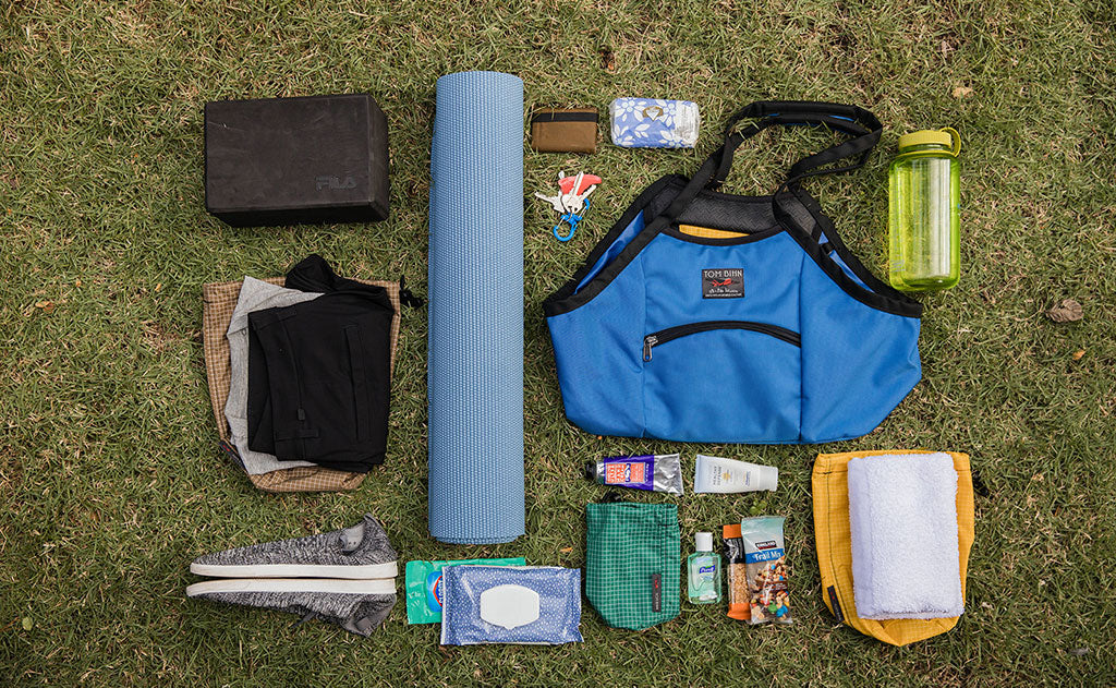 lifestyle visible^^The Truckasana with all the items that fit in it next to it. Yoga block, wallet, keys, phone, water bottle, yoga mat, a pair of shoes, yoga towel, two snack bars, hand sanitizer, sunscreen, and wipes.