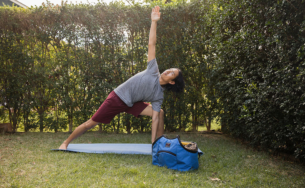 lifestyle visible^^Person on a yoga mat doing side angle pose. The Truckasana is next to them.
