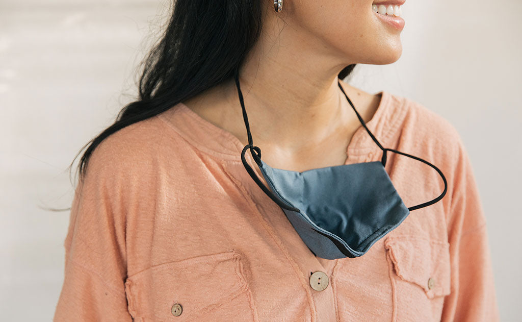 visible variant ME00010-LO^^Person wearing the V5 Mask, Pacific Blue, size Small/Medium. The mask is resting on their sternum thanks to the convenient lanyard.