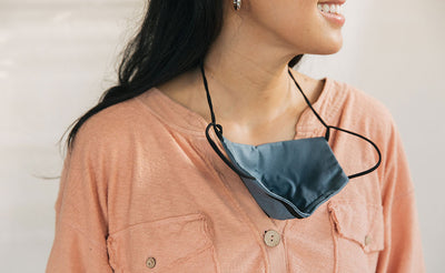 visible variant ME00010-LO^^Person wearing the V5 Mask, Pacific Blue, size Small/Medium. The mask is resting on their sternum thanks to the convenient lanyard.