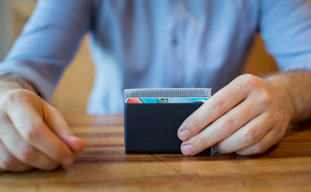 visible variant TB1277-BJ TB1277-LJ TB1277-CJ TB1277-DJ TB1277-IJ TB1277-VJ TB1277-GJ TB1277-BH TB1277-DH TB1275-BJ TB1275-LJ TB1275-CJ TB1275-DJ TB1275-IJ TB1275-VJ TB1275-GJ TB1275-BH TB1275-DH^^A person holding a Nik's Minimalist Wallet.