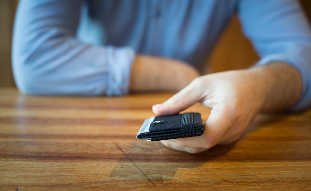 visible variant TB1277-BJ TB1277-LJ TB1277-CJ TB1277-DJ TB1277-IJ TB1277-VJ TB1277-GJ TB1277-BH TB1277-DH TB1275-BJ TB1275-LJ TB1275-CJ TB1275-DJ TB1275-IJ TB1275-VJ TB1275-GJ TB1275-BH TB1275-DH^^A person holding a Nik's Minimalist Wallet.