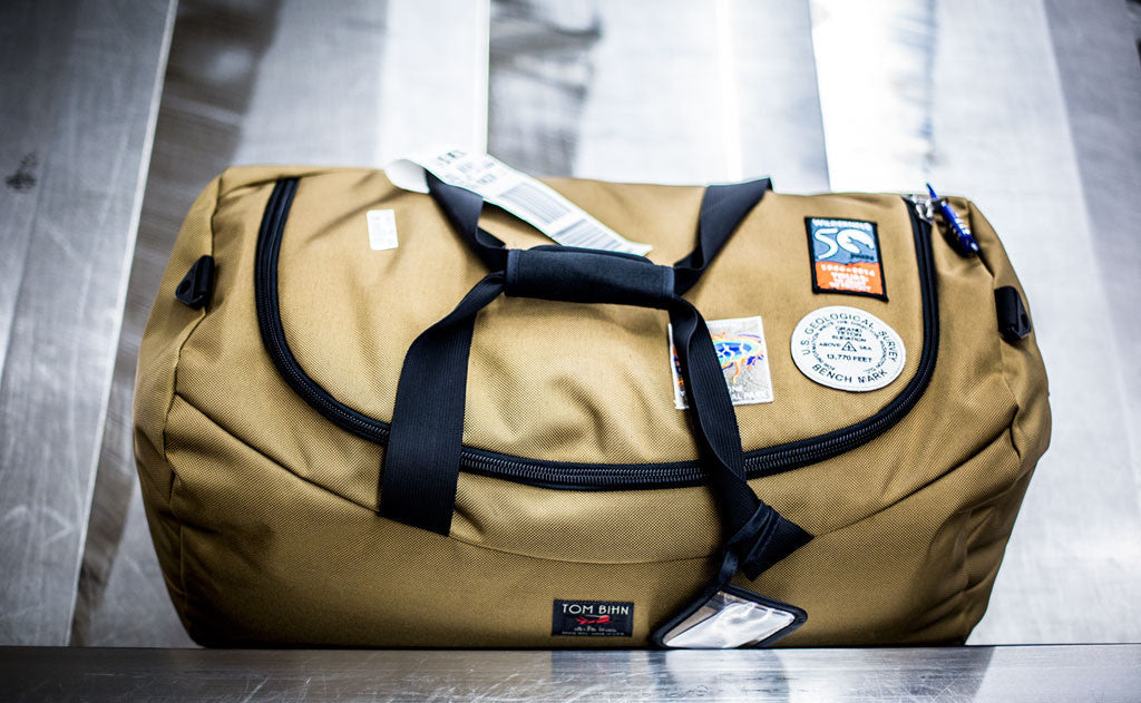 lifestyle visible ^^ A Yeoman Duffel with sewn on patches on an airport conveyor belt