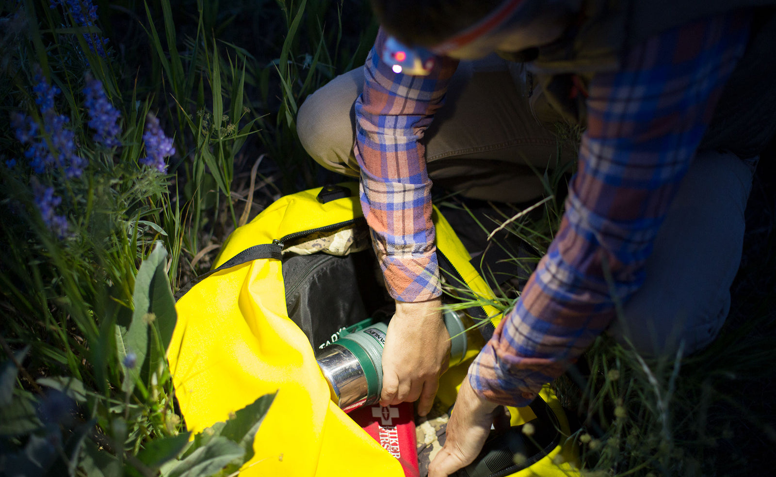 lifestyle  visible^^A person wearing a headlamp opening a Small Canary Yeoman Duffel at night.