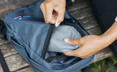 visible lifestyle^^A person retrieving a Small Q-Kit from the horizontal slash pocket.